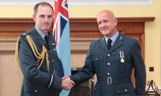 Air Commodore Gerry Mayhew presents Squadron Leader Edward Larkin with his Operational Service Medal.