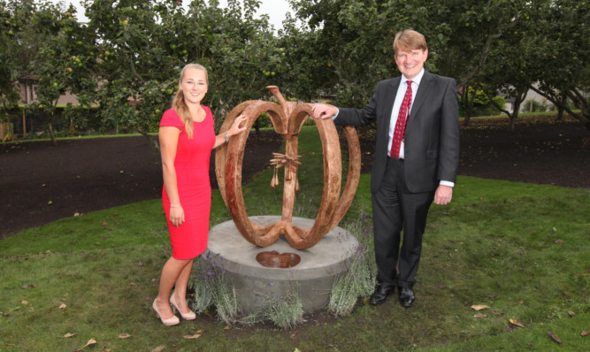Charlotte Lorimer and John Murphy of Robertson Homes with the Apple of Life sculpture.