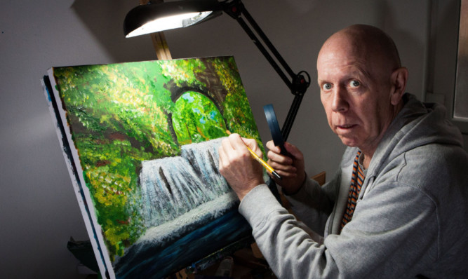 Derek ORourke at the easel with his paintbrush and magnifying glass.