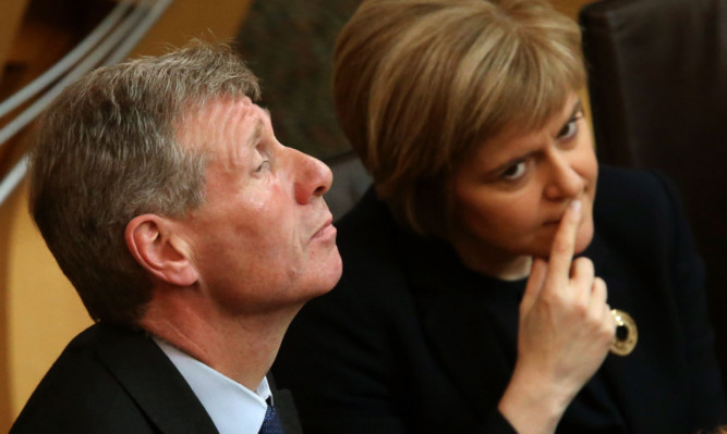 Justice Secretary Kenny MacAskill
 with Deputy First Minister Nicola Sturgeon in the chamber at the Scottish Parliament.