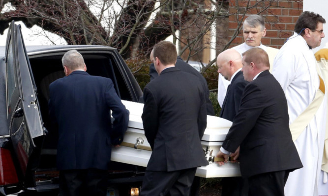 Pallbearers carry a coffin out of St Rose of Lima Roman Catholic Church after the funeral of one of the young victims, Jessica Rekos.