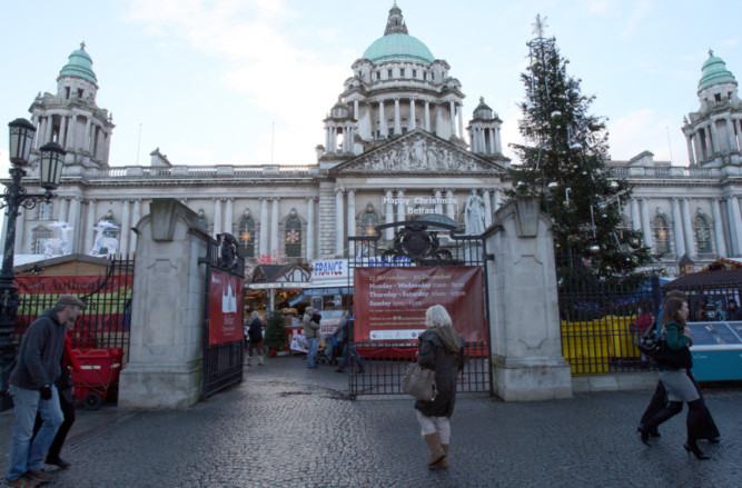 The Christmas market in front of Belfast City Hall with the Union flag removed from the flag pole at the front of the building.