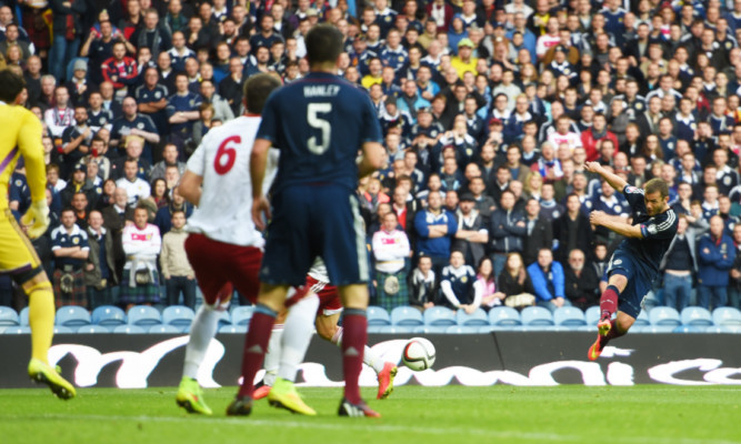 Shaun Maloney (right) shoots towards goal where his shot is deflected into the net.