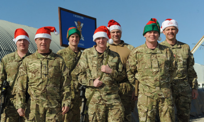 Sergeant Robert Duncan from Mayfield, Corporal John McClurg from Stranraer, Private Jamie McAllister from Tillicoultry, Private Danie McInally of Addiewell in West Lothian, Sergeant John Gray from Stoneyburn, Sergeant Gavin Conington from Bonnyrigg and Captain Gary Wallace, of the Royal Scots Borderers, 1st Battalion, the Royal Regiment of Scotland, get in the Christmas spirit at Camp Tombstone, Helmand Province.