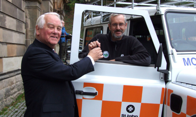 Charles Munro, senior member of St John Scotland, handing the keys of the vehicle to team leader Bill Rose.