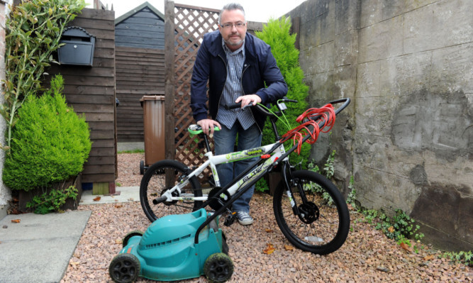 George McIrvine with the bicycle and lawnmower that were recovered.