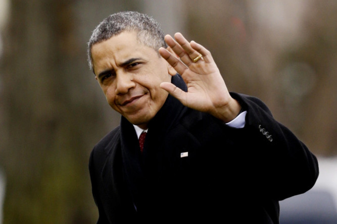 President Barack Obama waves as he returns from his holidays early to deal with financial problems.