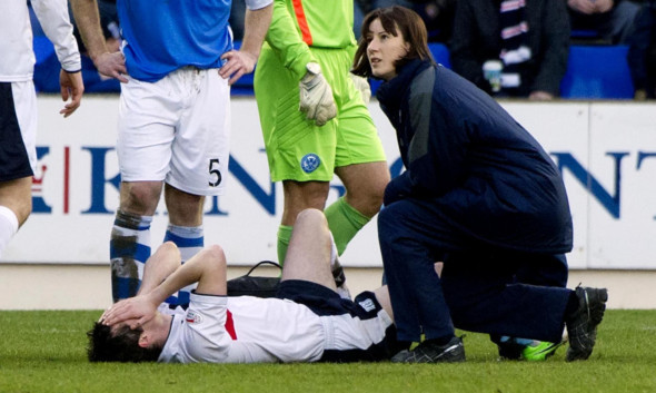 Stephen O'Donnell receives initial treatment after suffering his injury in the match at McDiarmid Park.