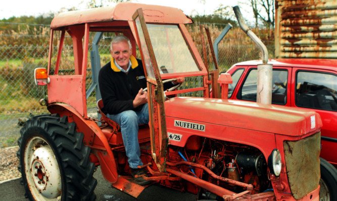 Strathmore Vintage Vehicle Club chairman Allan Burt with a 1967 Nuffield 4/25 tractor, one of the items appearing in this weekends auction.
