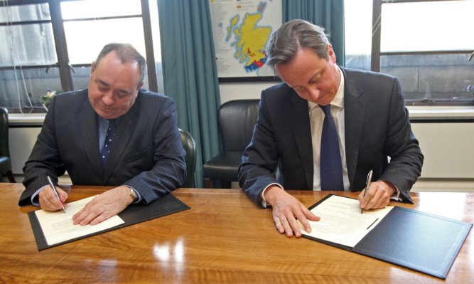 First Minister Alex Salmond (left) and Prime Minister David Cameron sign the Edinburgh  Agreement.