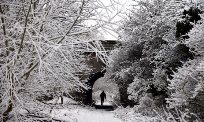 A man walks his dog in the snow in Gunthorpe, Nottinghamshire. The snow has been moving north and is set to hit large parts of Scotland today.