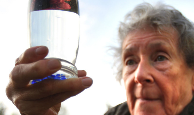 Tummel Bridge resident Maureen Robertson holds up a glass of the potentially life-threatening tap water.