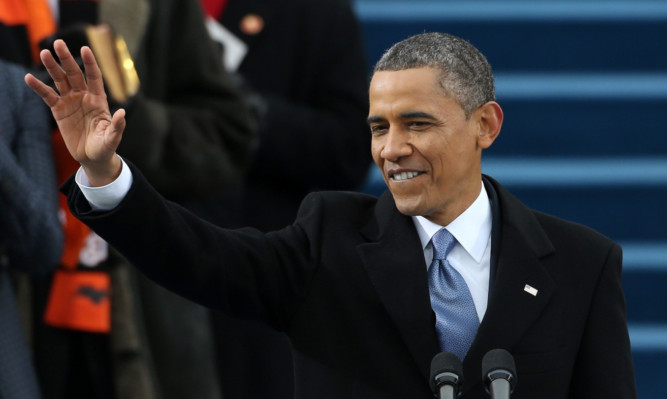 President Barack Obama waves before speaking to the crowds during the inauguration at the US Capitol.