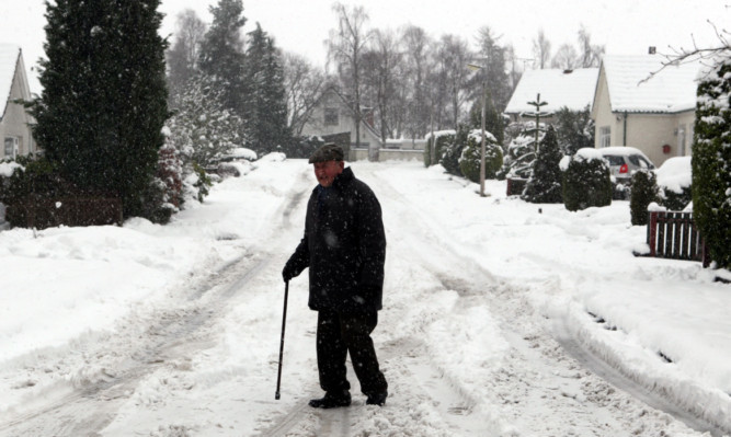 An elderly man ventures out into the snow in Auchterarder.