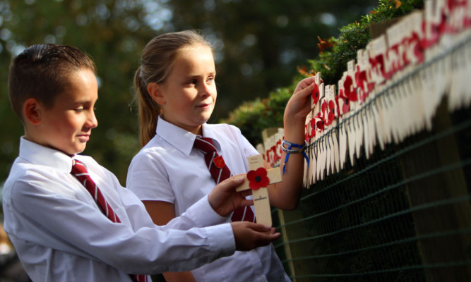 Keir McLauchlan and Emma Simpson placing crosses on the memorial.