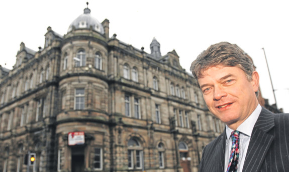 Dr Halliday with the old Post Office building that has been bought by Dundee High School.