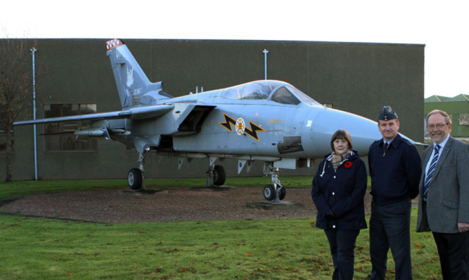 Community council chairman Carrol Finnie, Wing Commander Neville Clayton and Councillor Tim Brett beside the F3 Tornado gate guard.