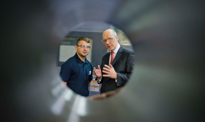 Finance Secretary John Swinney inspects the work at the Dundee plant