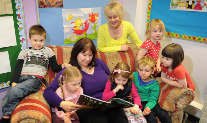 Kim Cessford - 31.01.13 - pictured in the nursery at Whitehills Primary School in Forfar are some of the children who are enjoying more comfort in the reading corner thanks to a donation of a sofa from the Forfar Resource Store - seated l to r - Nairn Cameron, Lauryn Russell, Early Years Practicioner Jen Blackie, Kaede Robertson, Lewis Strachan, Amelie Saddler and Eva Warburton with back - Ann Nicoll from the Forfar Resource Store