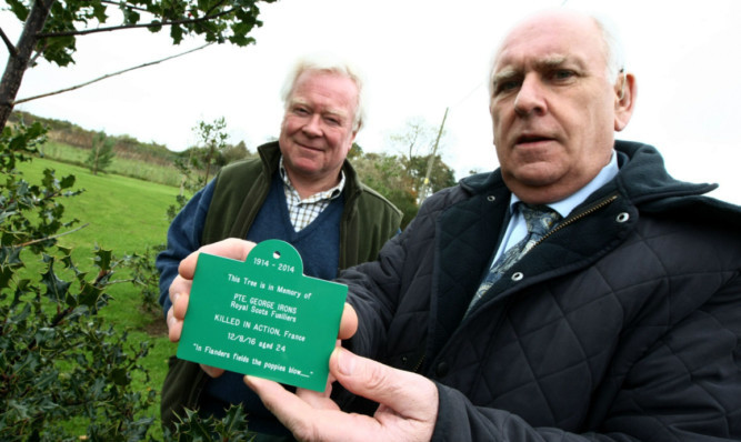 Hamish Evatt and Iain Richmond with one of the plaques to be attached to trees at Monikie Memorial Hall.