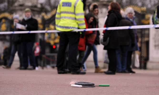 A cornered off area containing knives, a hat and Taser wire outside Buckingham Palace in central London after a man was been Tasered by police.