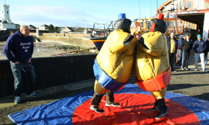 Arbroath lifeboat crew members Peter Ross (blue) and Tommy Yule (red) battle it out in the sumo ring as part of the fun day.