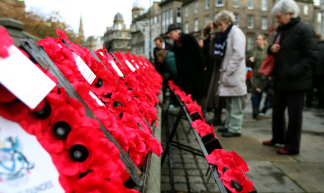 Members of the public inspect some of the wreaths laid in DUndee.