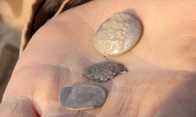 Jim Connolly uncovered this late 18th Century artillery button, a hammered silver coin from the reign of Edward I, centre, and  a William III five- shilling Scots coin.