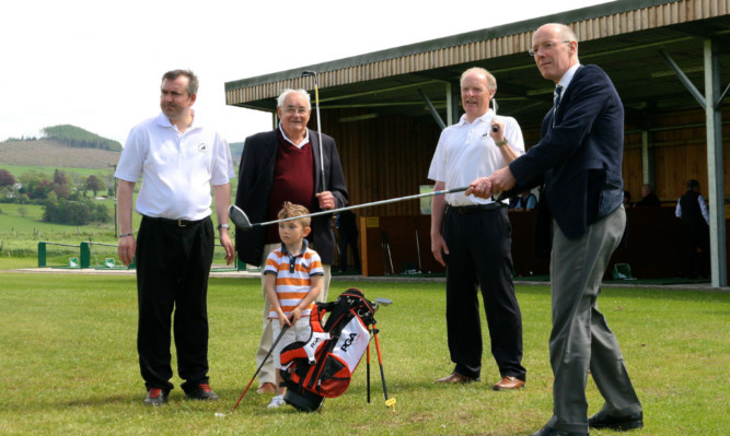 Club professional Mark Pirie, Neil Panton, four-year-old member Daniel Kearney and club captain Ron Bell watch John Swinney MSP tee off at the opening of the Pitlochy Golf Academy in May.
