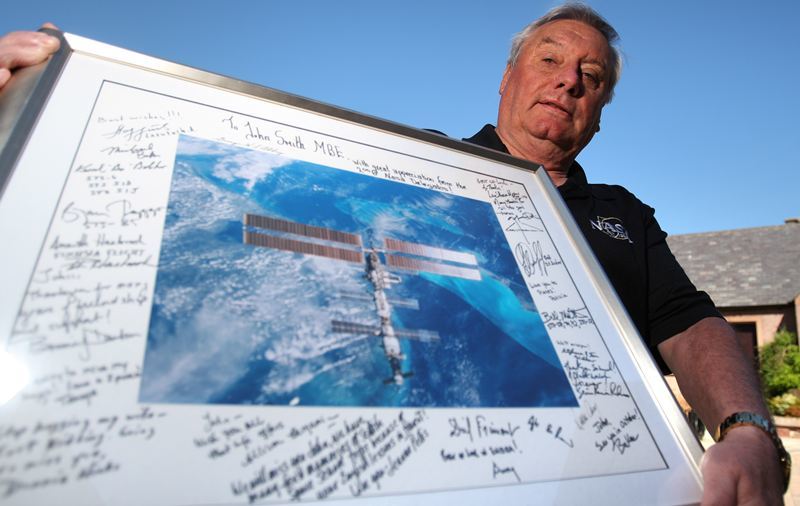 Kris Miller, Courier, 31/05/10, News. Picture today at Jamieson's Close, Kirriemuir. Pic shows John Smith who has recieved an invitation from NASA to the last shuttle launch this September. Pic shows John (who is a former Security Advisor to NASA) with the framed signed picture he recieved when he left NASA.