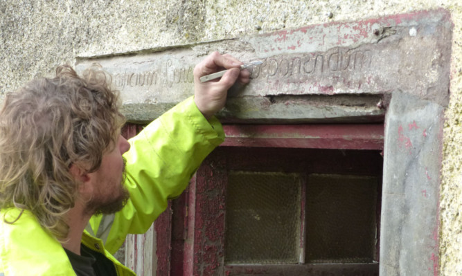 Stone conservator Eric Waanders repairs the Horn inscription.
