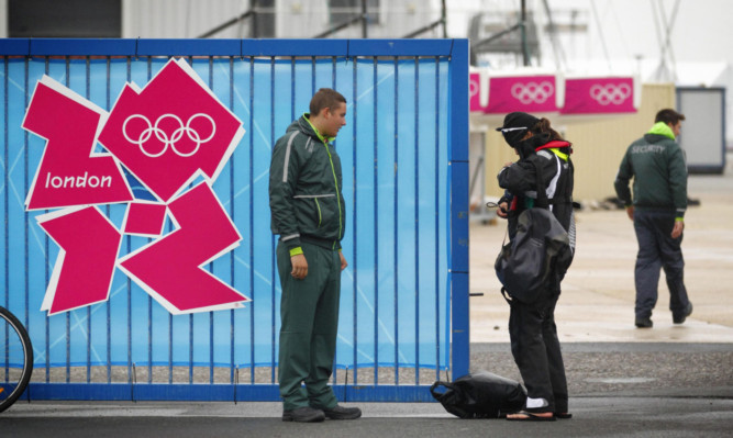 A G4S employed security guard checks an athlete's accreditation during the Olympic Games.