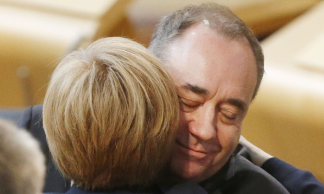 Alex Salmond hugs Nicola Sturgeon after resigning as First Minister during a statement to the Scottish Parliament.