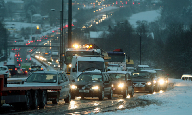 Long tailbacks on the A90 at Powrie Brae north of Dundee yesterday during the snow. Drivers are now being urged to watch for flooding during today's thaw.