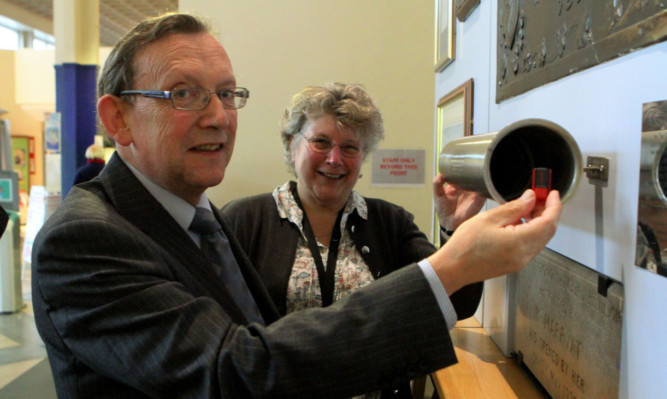 NHS Tayside chairman Sandy Watson puts a USB stick, containing images of Ninewells, into the time capsule, watched by Professor Jean Ker.