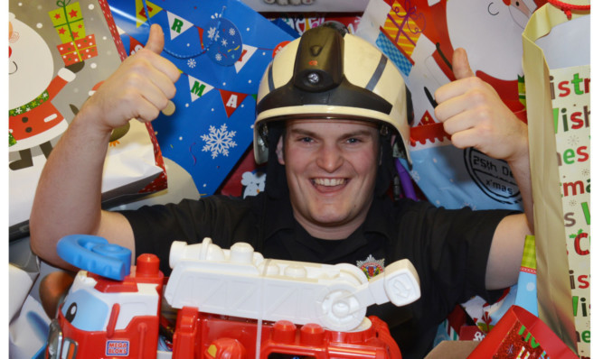 Methil Fire Station full of toys and presents for Fife Spirit of Christmas appeal, with firefighter Kevin Shields among the presents.