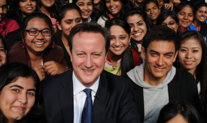 The Prime Minister poses with Bollywood superstar Aamir Khan (right) on his trip to India.