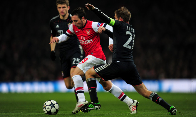 Santi Cazorla of Arsenal is challenged by Bayern Munich defender Philip Lahm.