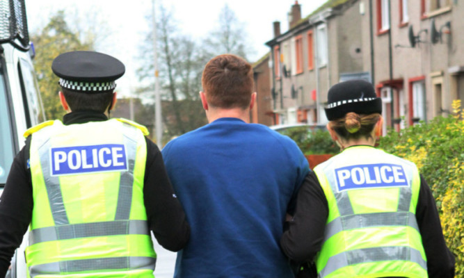 A suspect is led away after the raid in Findhorn Street in Fintry today.