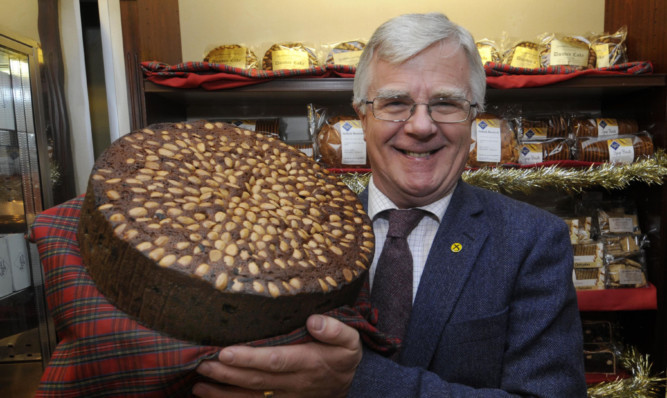MEP Ian Hudghton with a giant Dundee cake in Goodfellow & Steven, Broughty Ferry.
