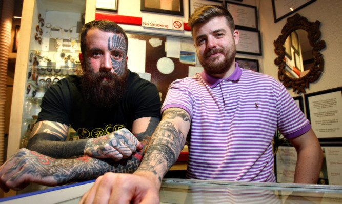 Tattoo artist Calum Stewart, left, with Jamie Shankland, who had a tattoo showing crowds of Dundonians gathered at the H Samuel clock inked on his arm.