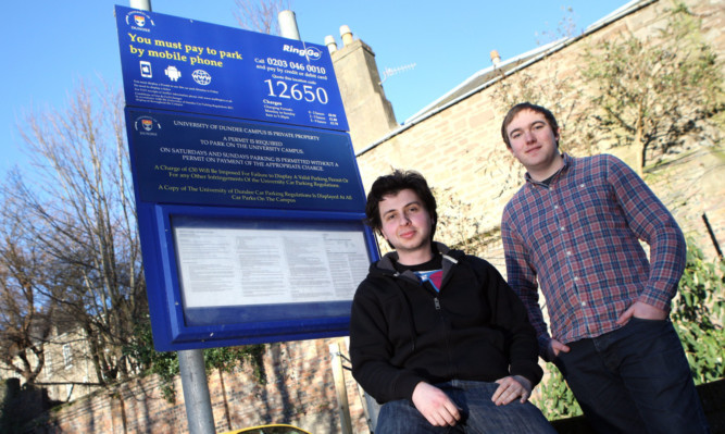 Luis Alcada and James Anthony from the church beside signs for the car park.