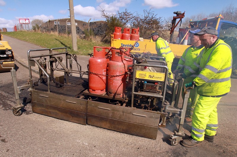 The "Rhinotherm" used by Tayside Contracts to fill in potholes. Pictured filling in potholes in Telford Road, Dunsinane Industrial Estate, Dundee, are l-r, Tayside Contracts Roadworkers Mike Thomson, Stephen McIntosh and Stephen Abbott.