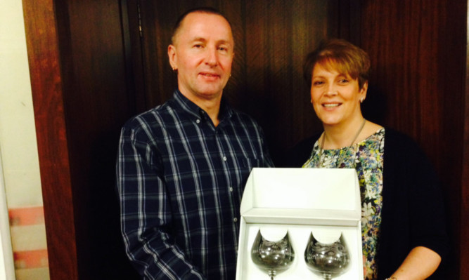 Andy Reid receiving his presentation from new Forfar Amateur Swimming Club president Lesley Cromar.