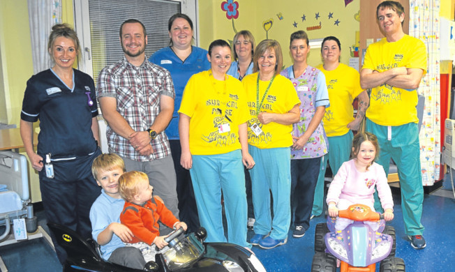 Euan Gray and his brother Calum with four-year-old Sarah Mann, parents and staff from Ward 29.