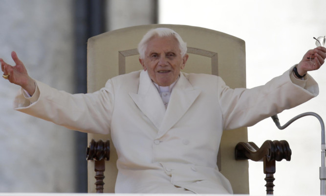 Pope Benedict XVI opens his arms during his final general audience in St. Peter's Square at the Vatican.