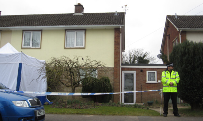 Police guard the property where the man and his partner were found shot dead in Devizes.