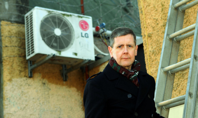 Mark McGowan, writer in residence, beside the damaged heat exchange unit.