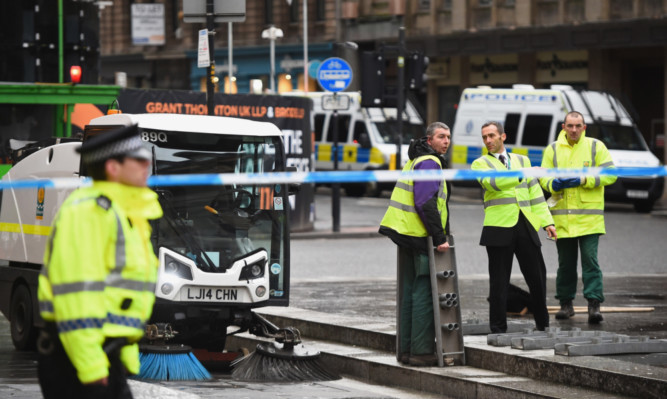Council workers clean Queen Street near the scene of Monday's bin lorry crash  in Glasgow.