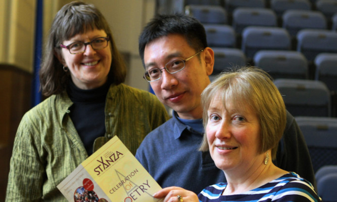 From left  Poets Erin Moure and Alvin Pang and StAnza director Eleanor Livingstone look over the festival brochure.